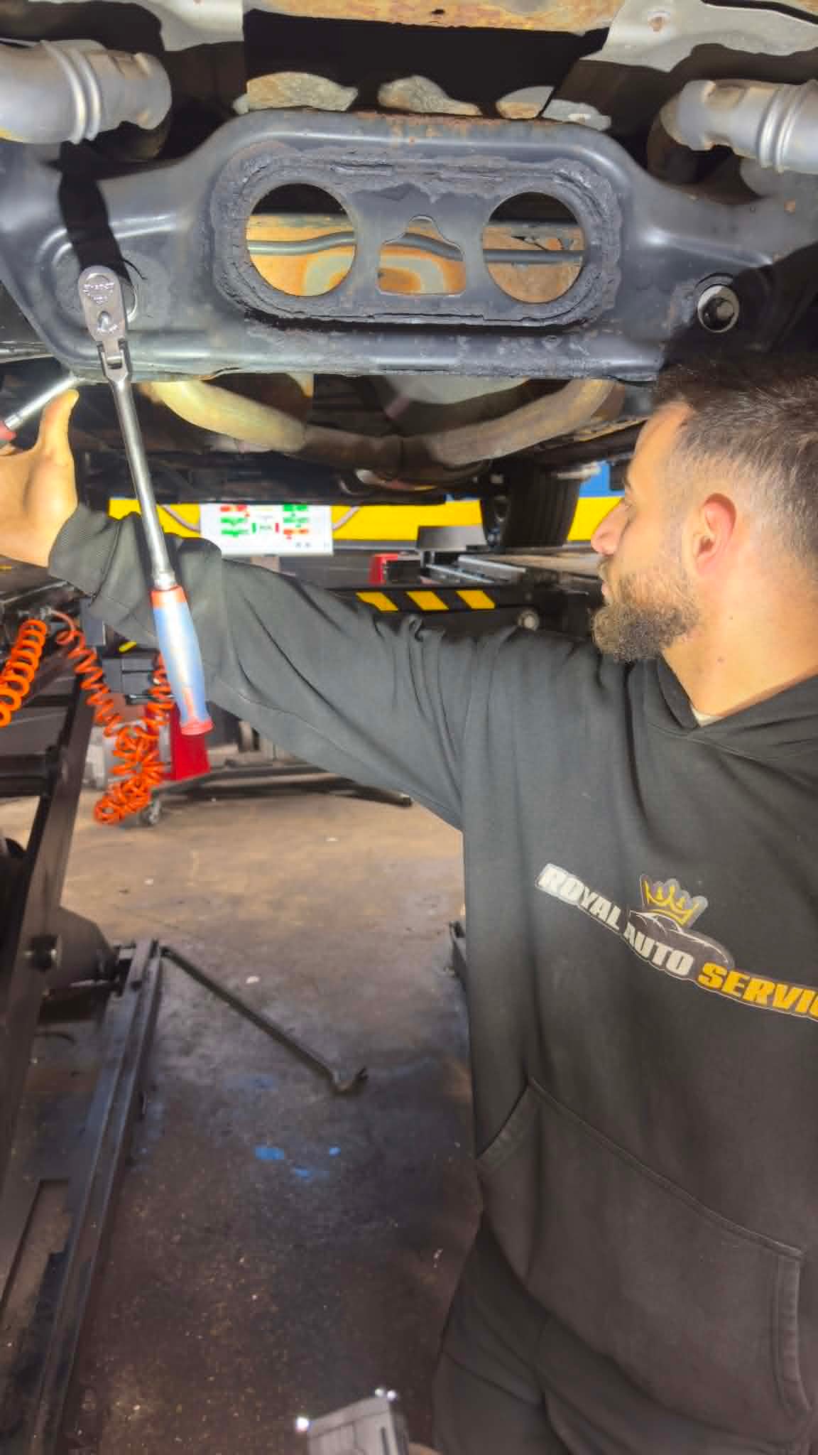 Royal Auto Service technician working under a vehicle